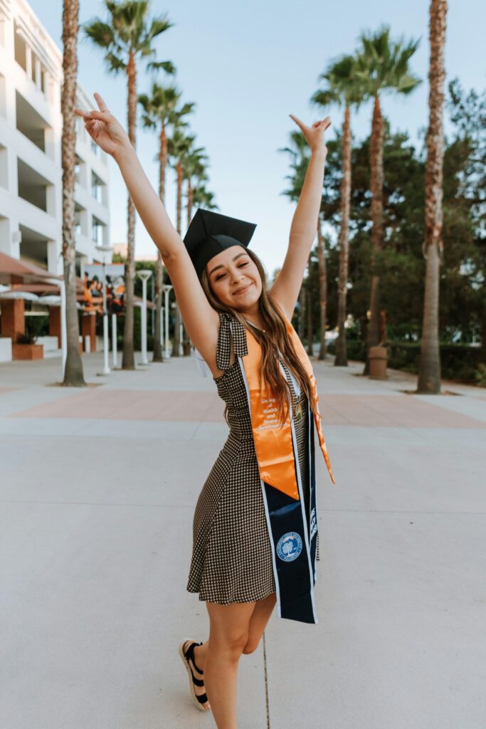 Joyful graduate celebrating outdoors in a cap and sash, symbolizing academic achievement and career readiness. Professional CV writing services