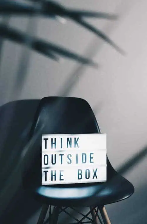Black chair with a 'Think Outside the Box' sign, inspiring creative career solutions.