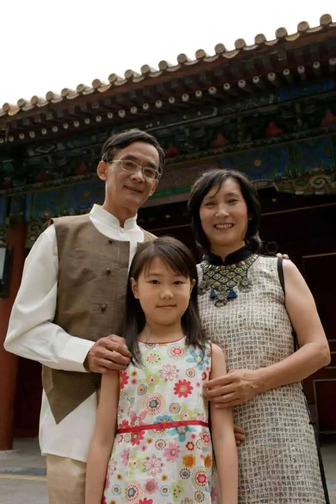 Asian immigrant family embracing cultural heritage in traditional attire