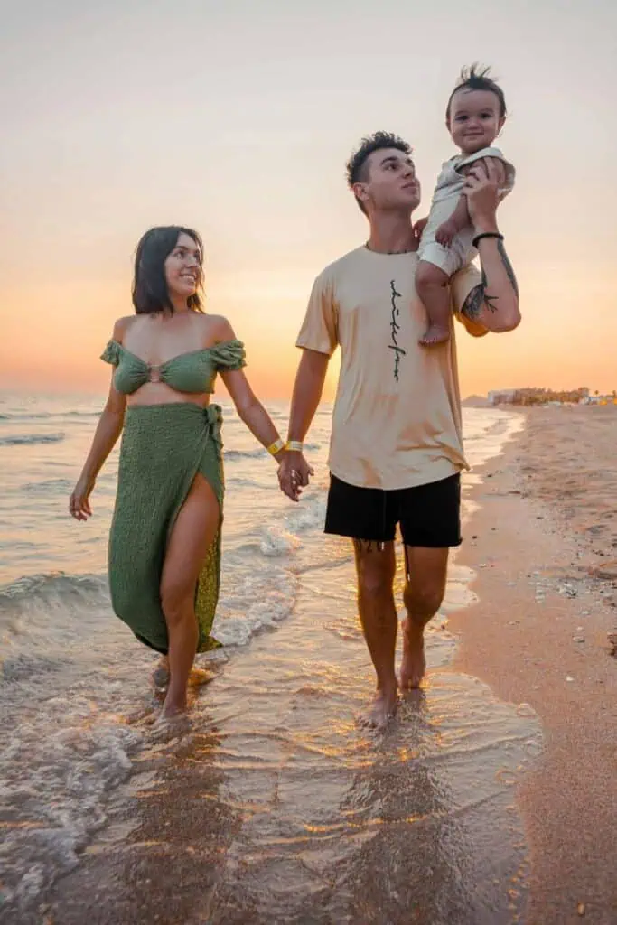 Young immigrant family enjoying work-life balance at the beach during sunset