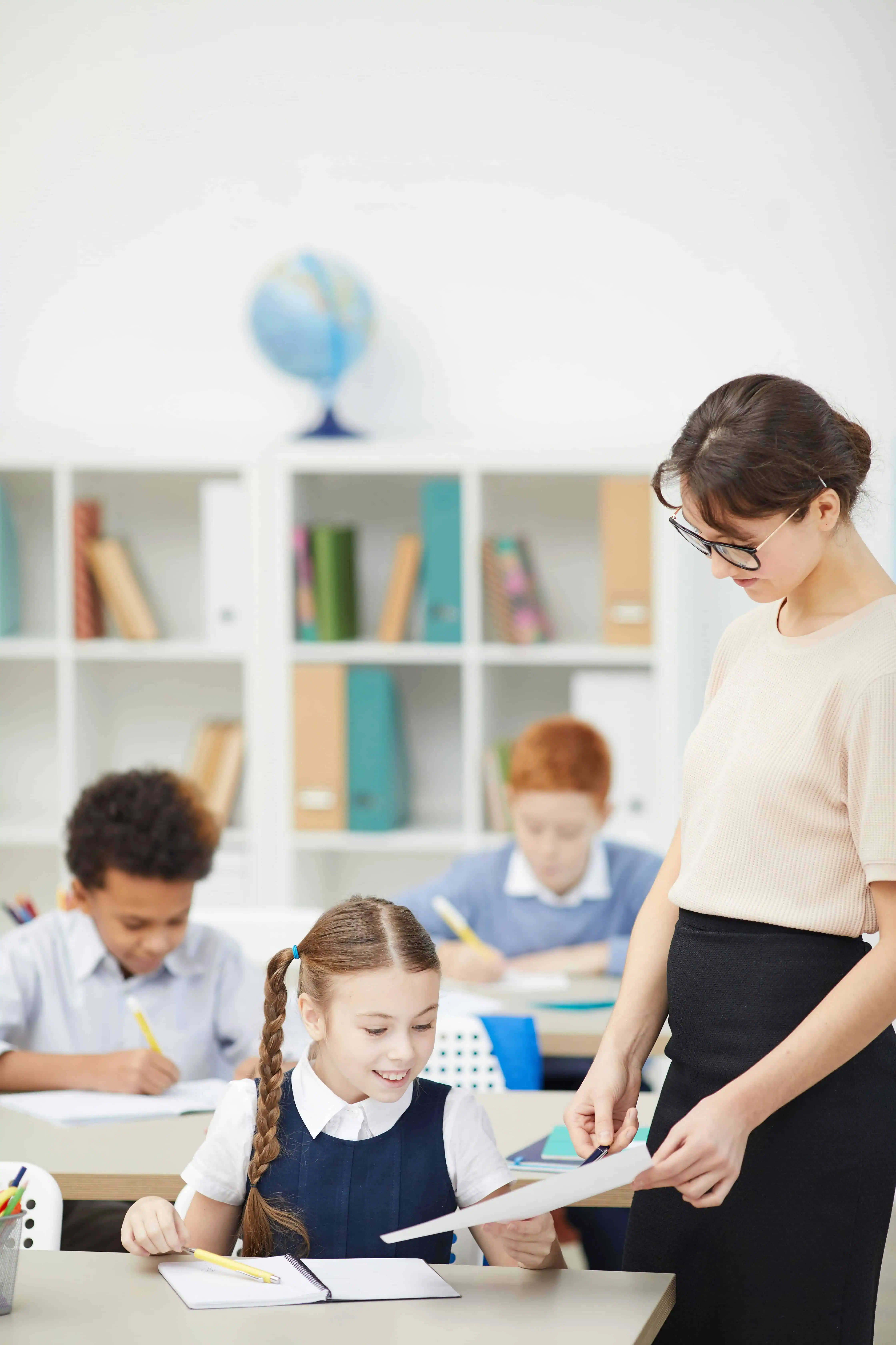 A teacher guiding a young student in a classroom, fostering learning, growth, and future career success through education and sports development