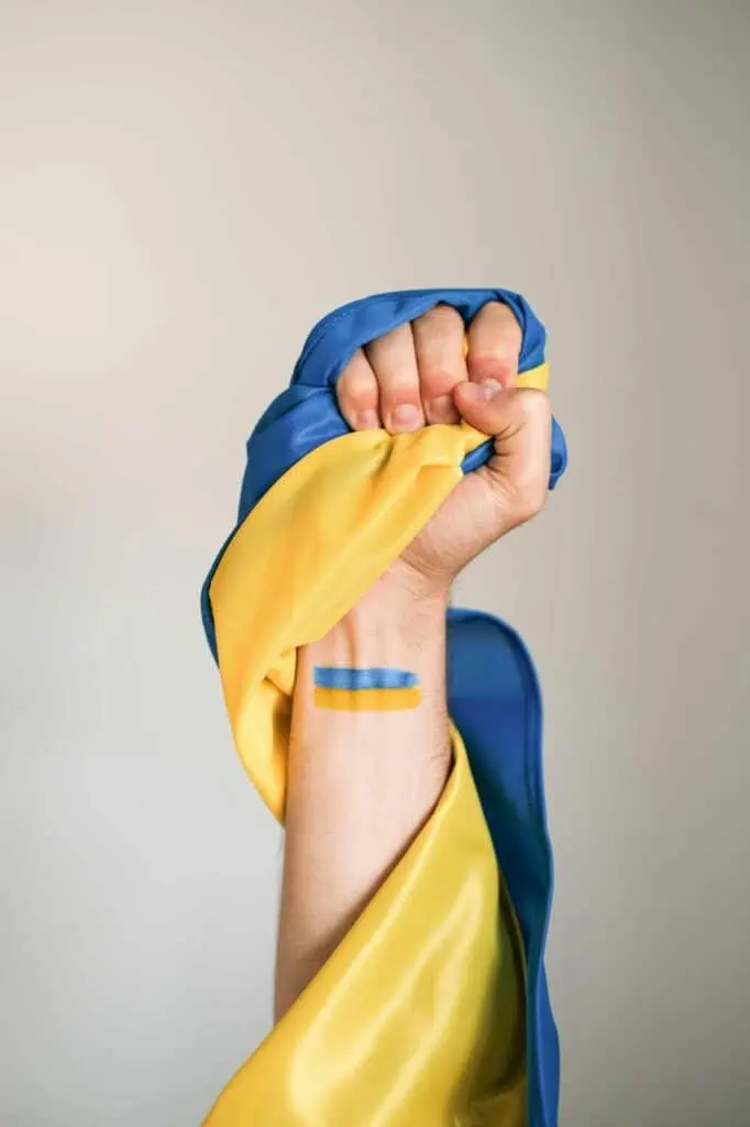 Raised fist wrapped in the Ukrainian flag, symbolizing strength, resilience, and cv4students support for Ukraine.