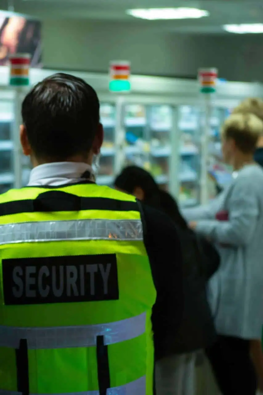 Airport security officer monitoring passenger screening area at terminal