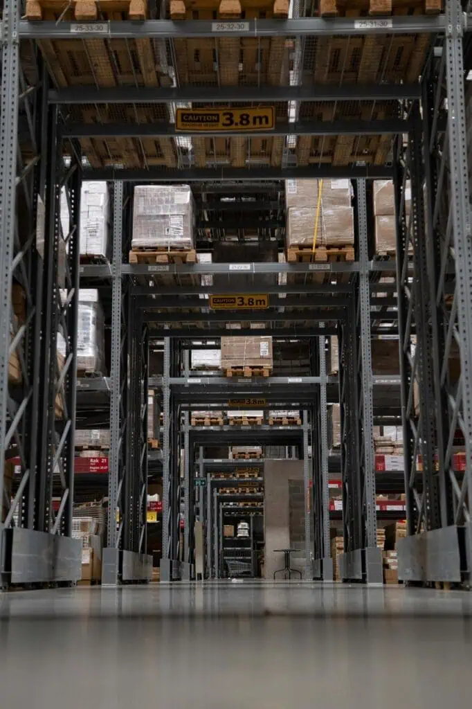 High-tech automated warehouse aisle with labeled shelving and stacked pallets