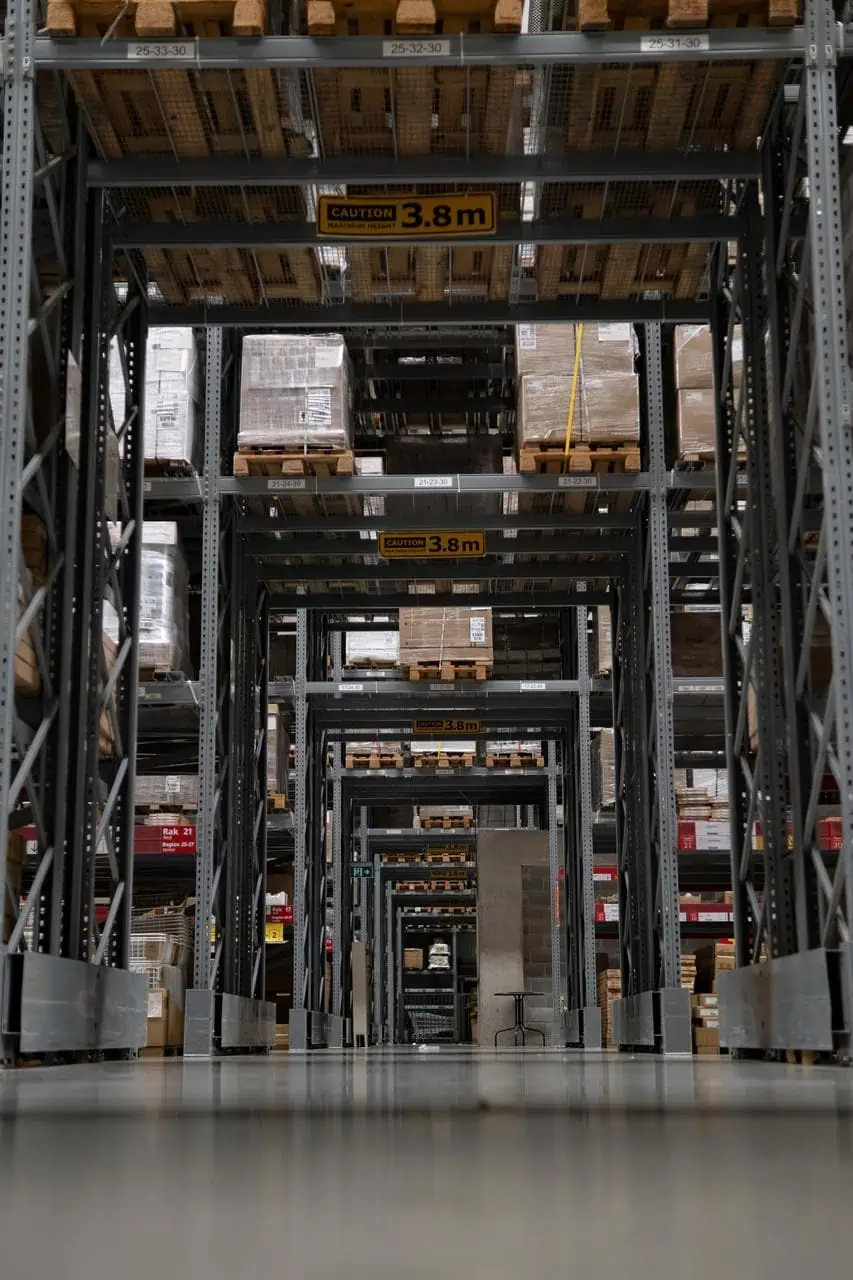 High-tech automated warehouse aisle with labeled shelving and stacked pallets