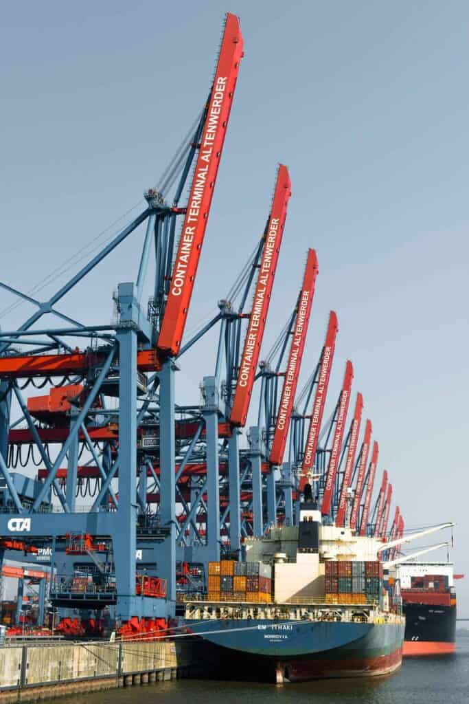 Port cranes loading containers onto cargo ship at Container Terminal Altenwerder