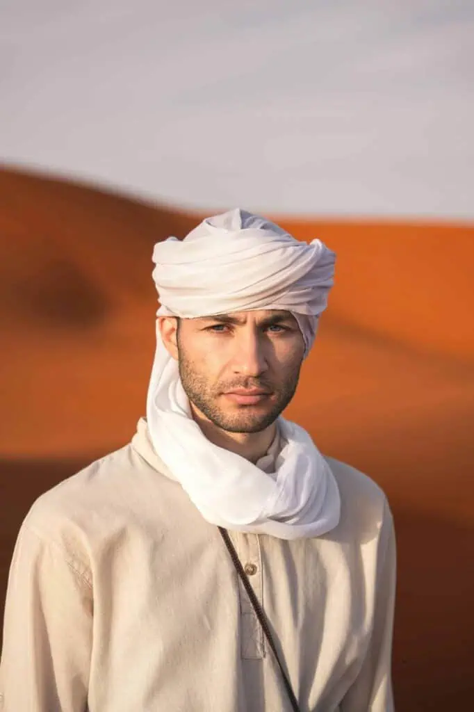 A young Moroccan student wearing traditional attire, standing confidently in the desert—symbolizing ambition, heritage, and career success with free CV creation services.