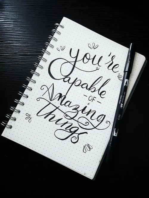 Notebook with handwritten motivational quote: 'You're capable of amazing things