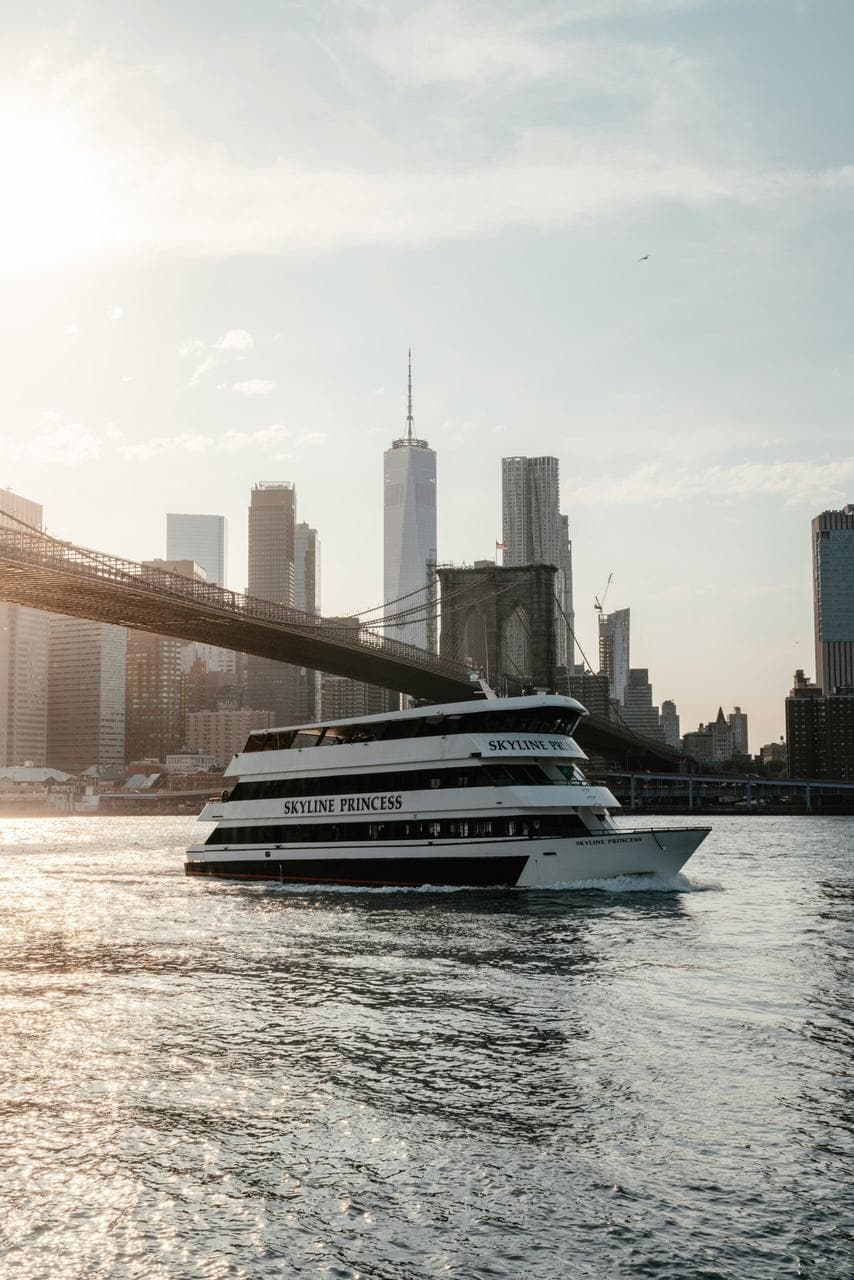 Ferry boat 'Skyline Princess' cruising past Brooklyn Bridge with NYC skyline in background