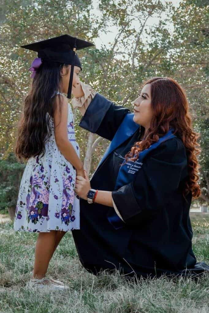 Graduate celebrating with her daughter, symbolizing the power of education and family support.