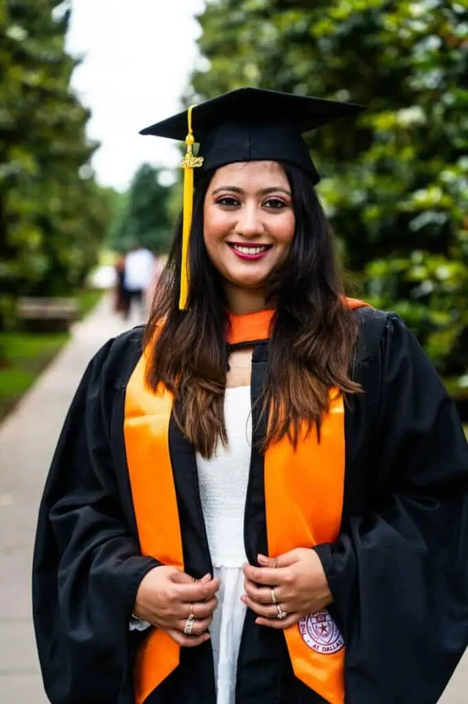 International student celebrating graduation in cap and gown.