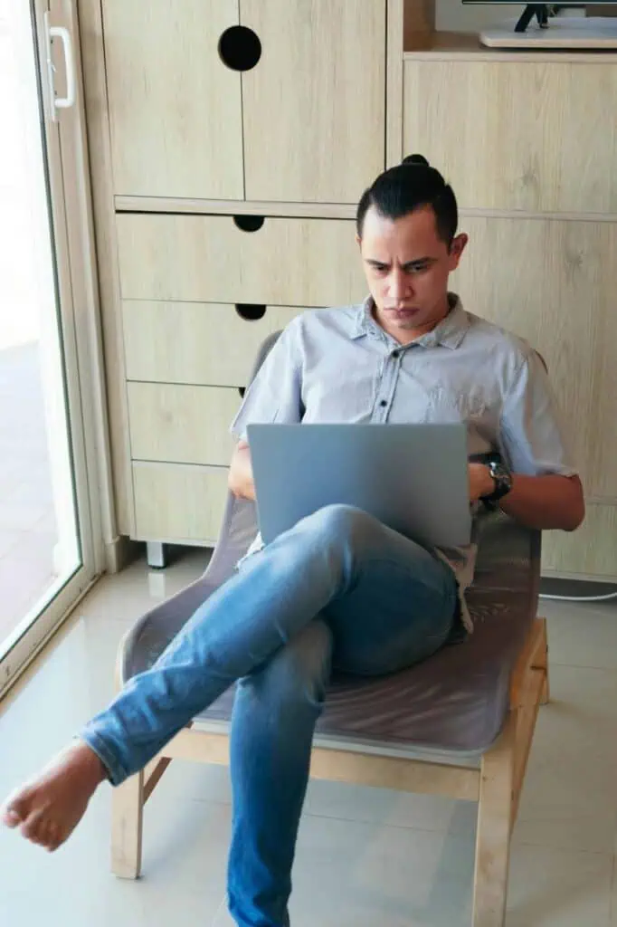 Man researching different career options on a laptop, exploring job opportunities and career planning strategies.
