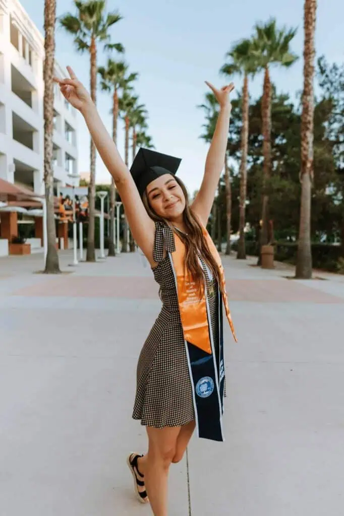 Joyful graduate celebrating outdoors in a cap and sash, symbolizing academic achievement and career readiness. Professional CV writing services