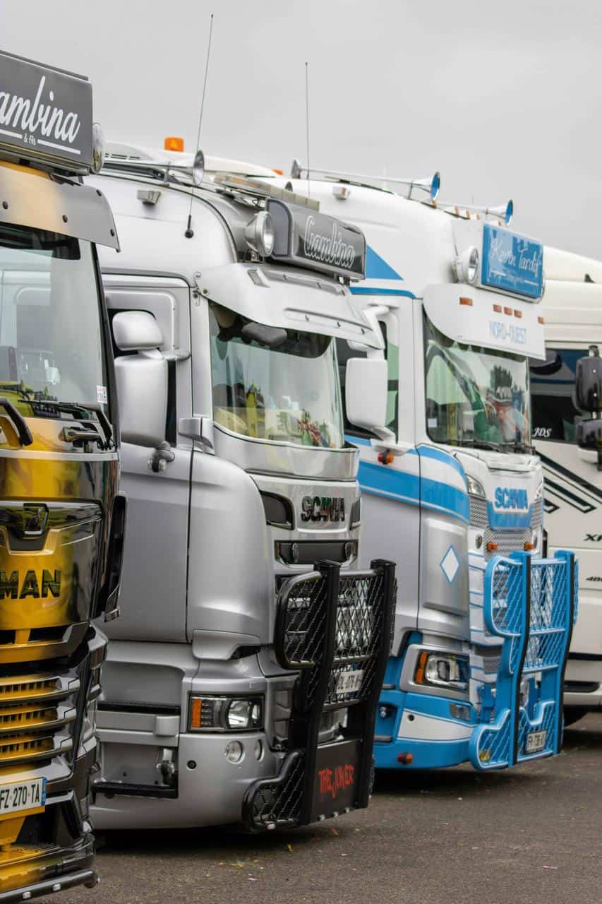 A lineup of professional long-haul trucks parked in a row, representing the trucking industry and career opportunities.