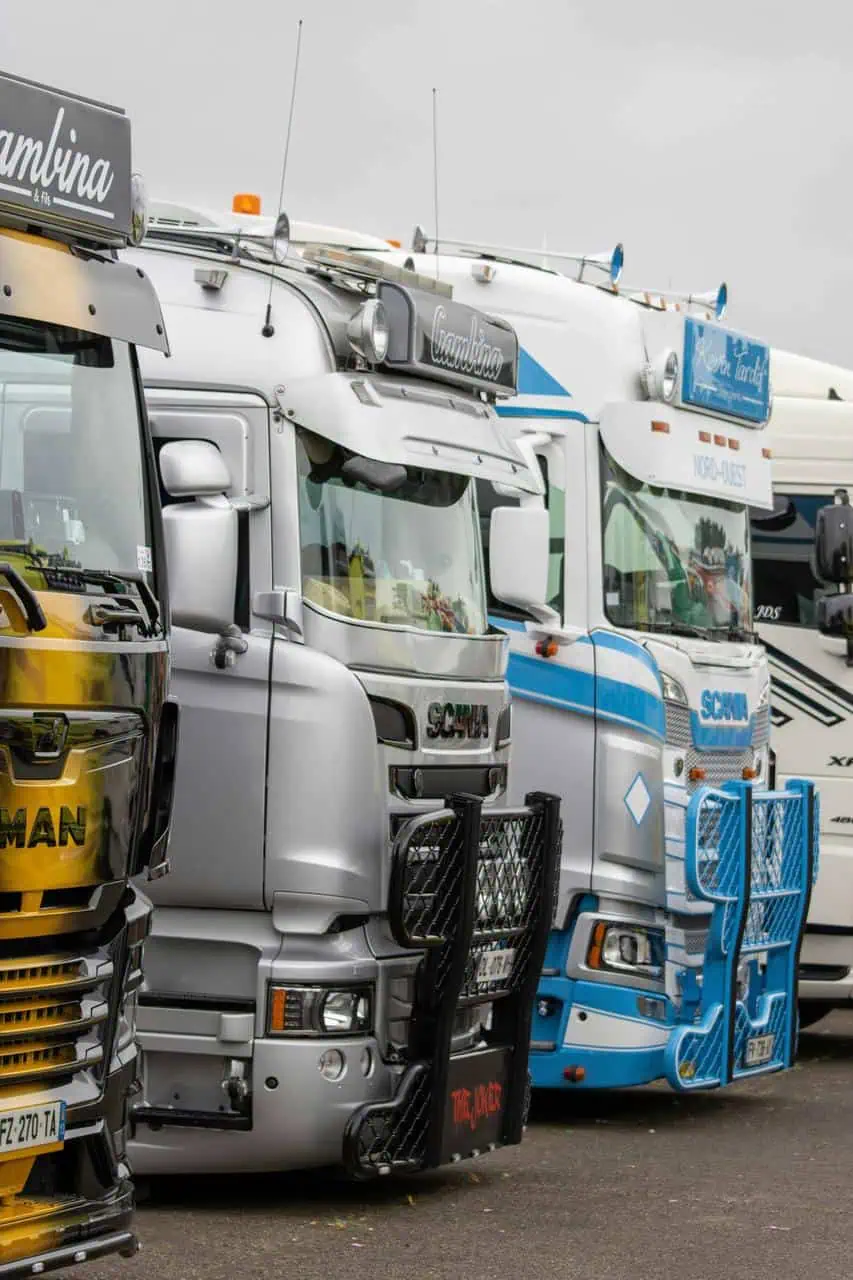 A lineup of professional long-haul trucks parked in a row, representing the trucking industry and career opportunities.