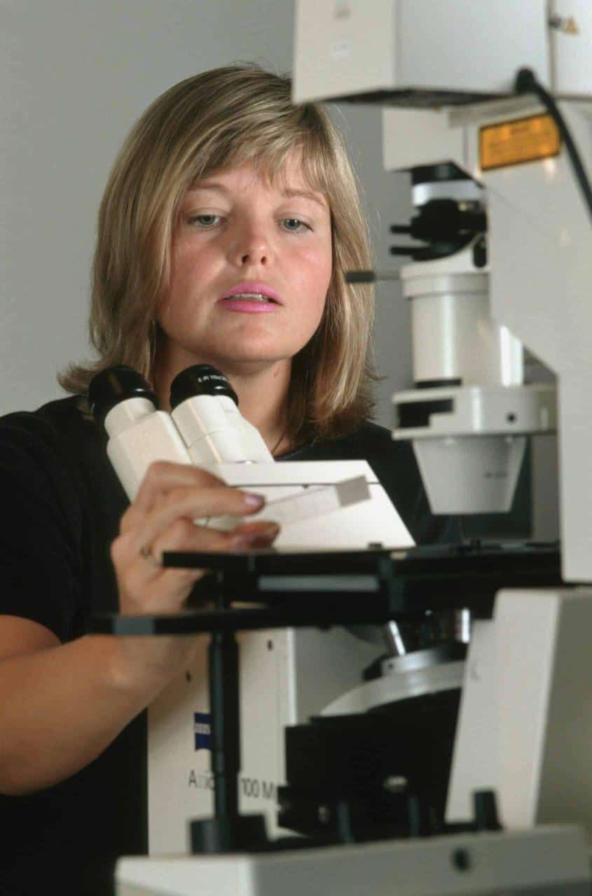 A marine biologist analyzing specimens under a microscope, conducting research on aquatic life and ecosystems
