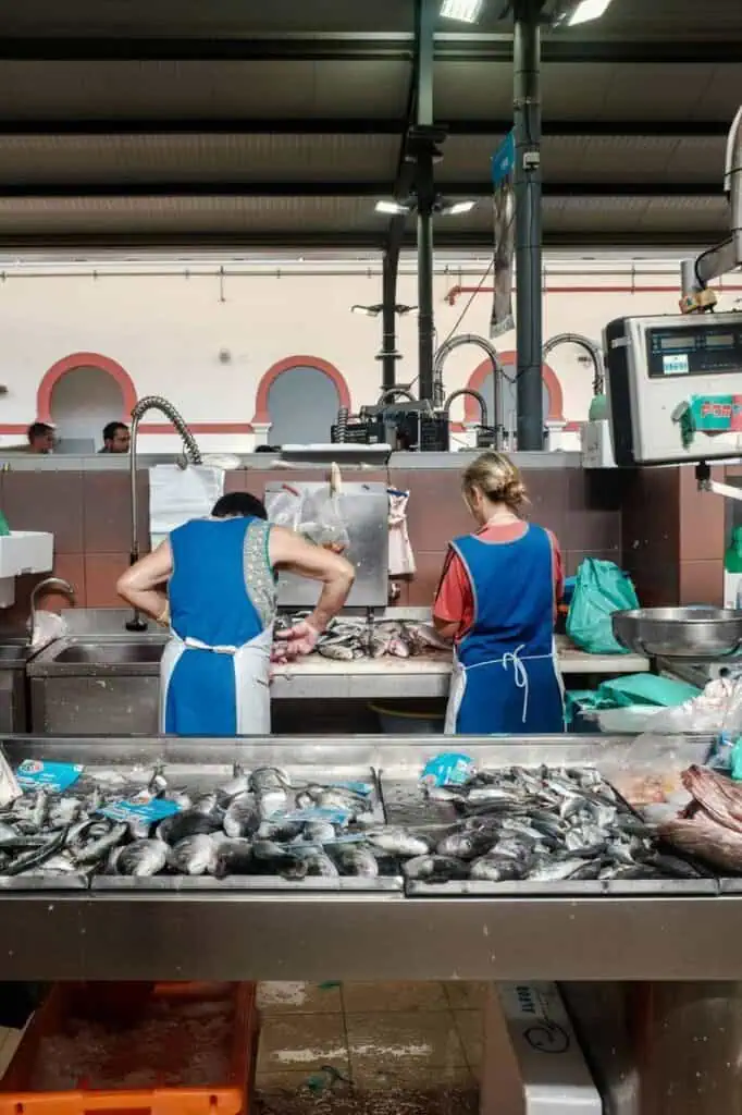 Workers in a seafood processing plant preparing fresh fish for packaging and sale.