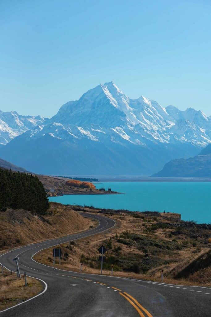 Scenic road leading to snow-capped mountains in New Zealand, symbolizing adventure, education, and career opportunities for students