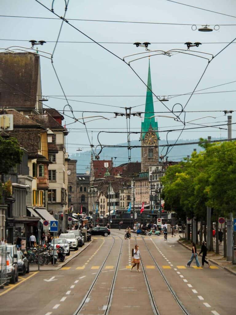 City street in Zurich, Switzerland, with trams, pedestrians, and historic architecture, representing student life and career opportunities in Switzerland.