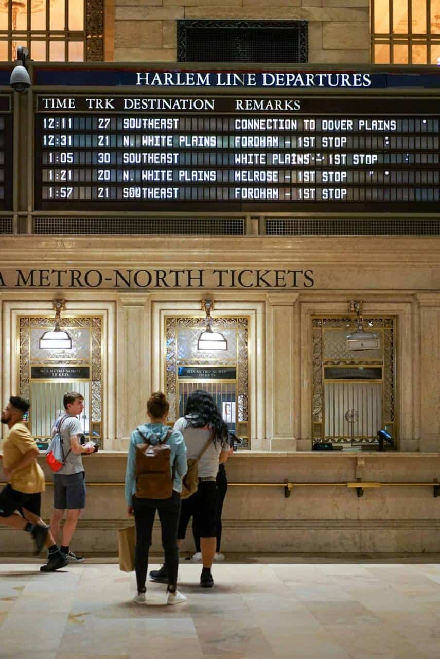 Passengers purchasing train tickets at a Harlem Line departures counter—highlighting career opportunities in customer service and passenger support roles.