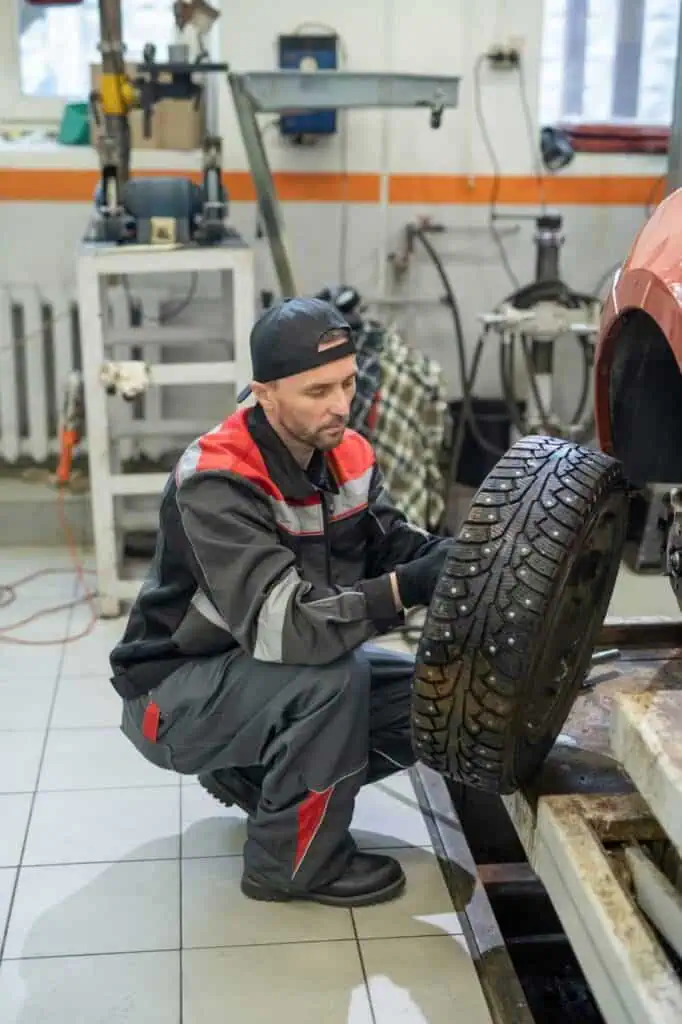 Tire technician installing winter tire in auto repair shop