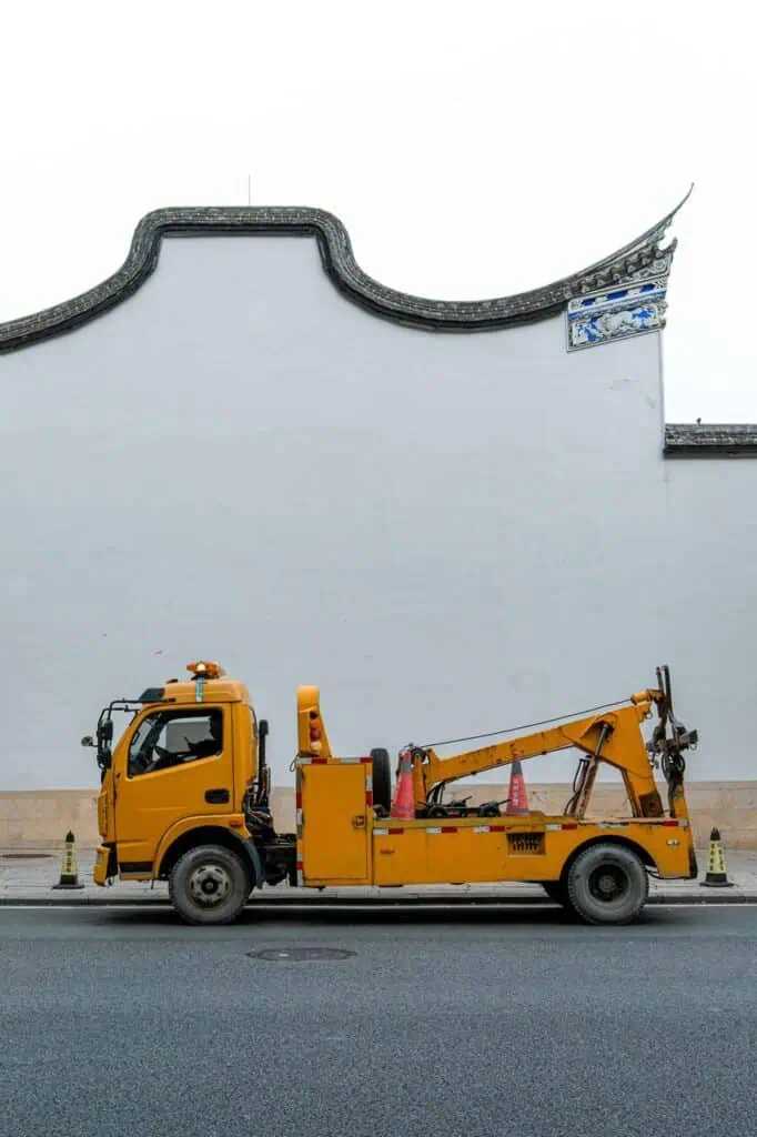 Yellow tow truck parked by the roadside, ready for emergency vehicle recovery service.