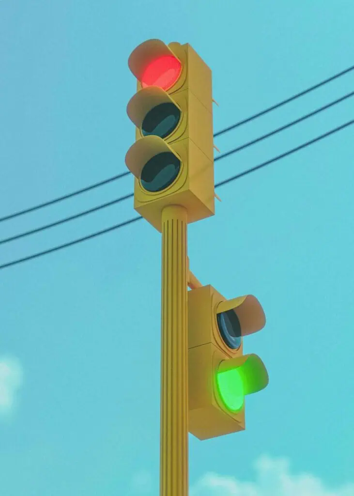 Modern traffic signal with red and green lights under a clear sky