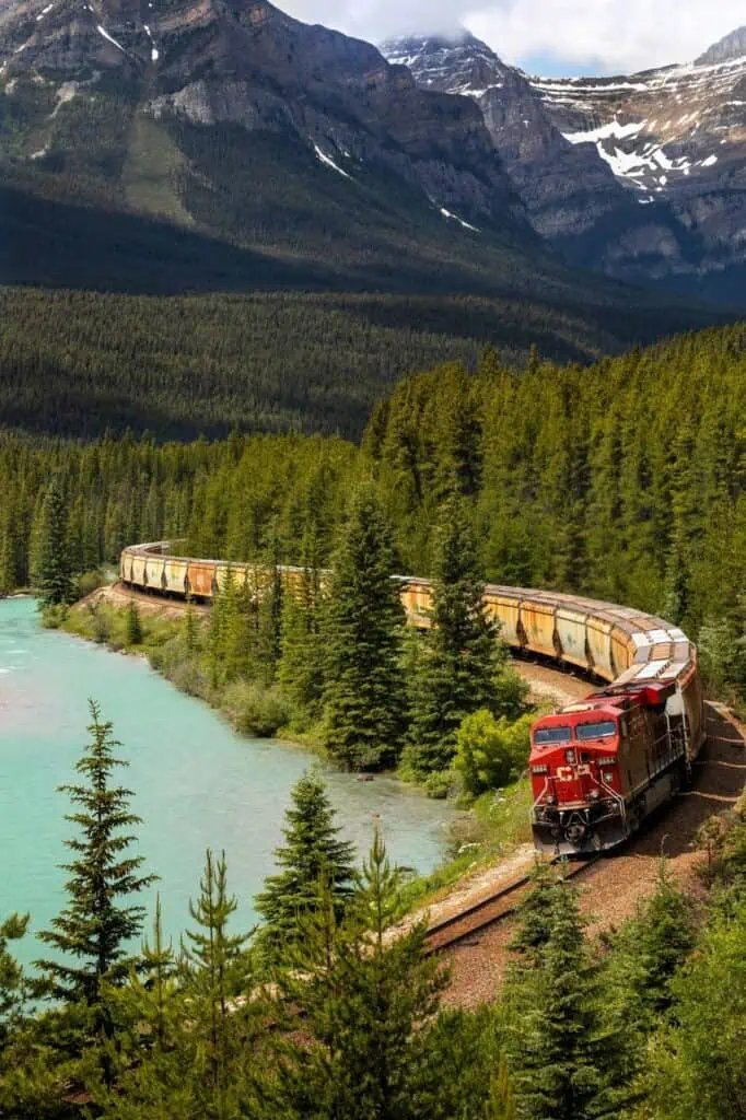A freight train winding through a scenic mountain landscape, symbolizing the strength and efficiency of transportation, warehousing, and distribution careers.