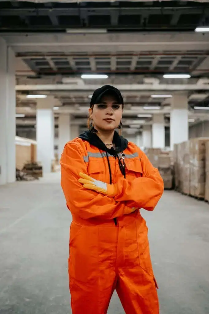 Warehouse security officer in orange uniform standing confidently in distribution center