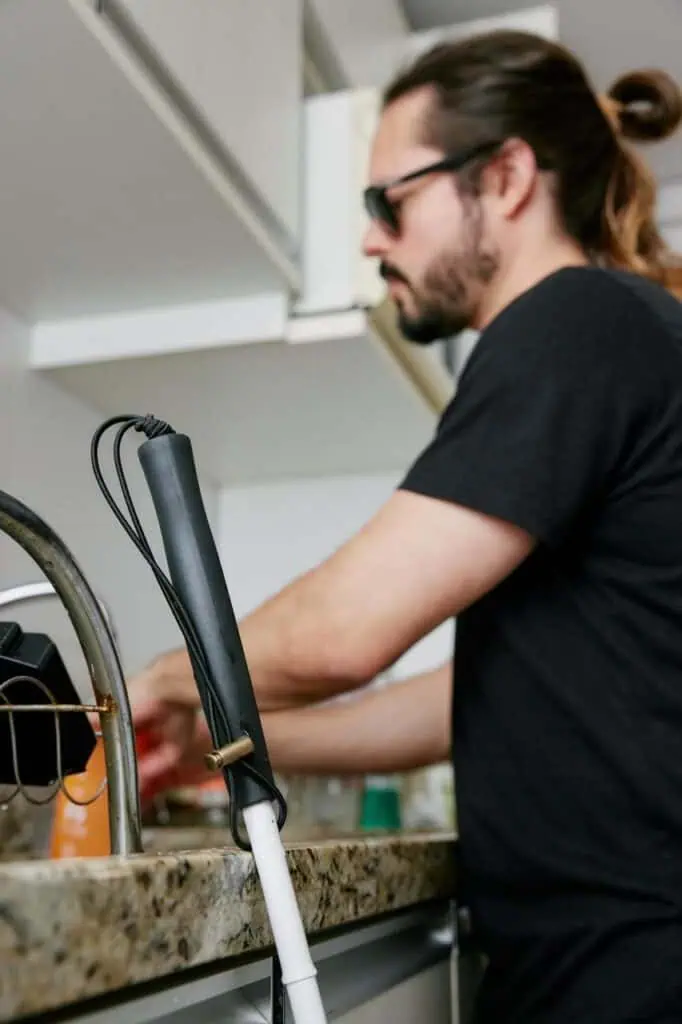 Blind dishwasher at work, using touch and skill to clean in a professional kitchen environment—representing inclusive employment and independence.