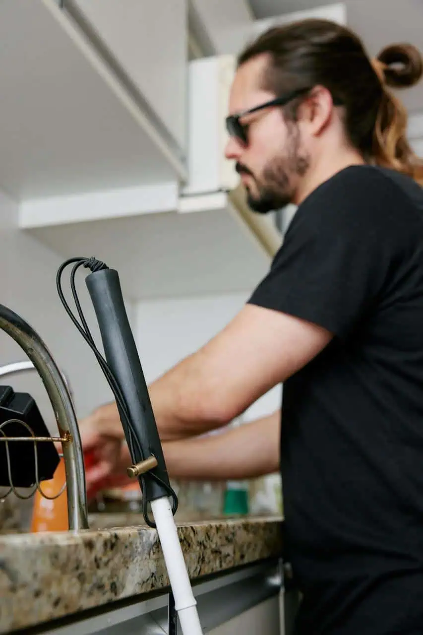 Blind dishwasher at work, using touch and skill to clean in a professional kitchen environment—representing inclusive employment and independence.