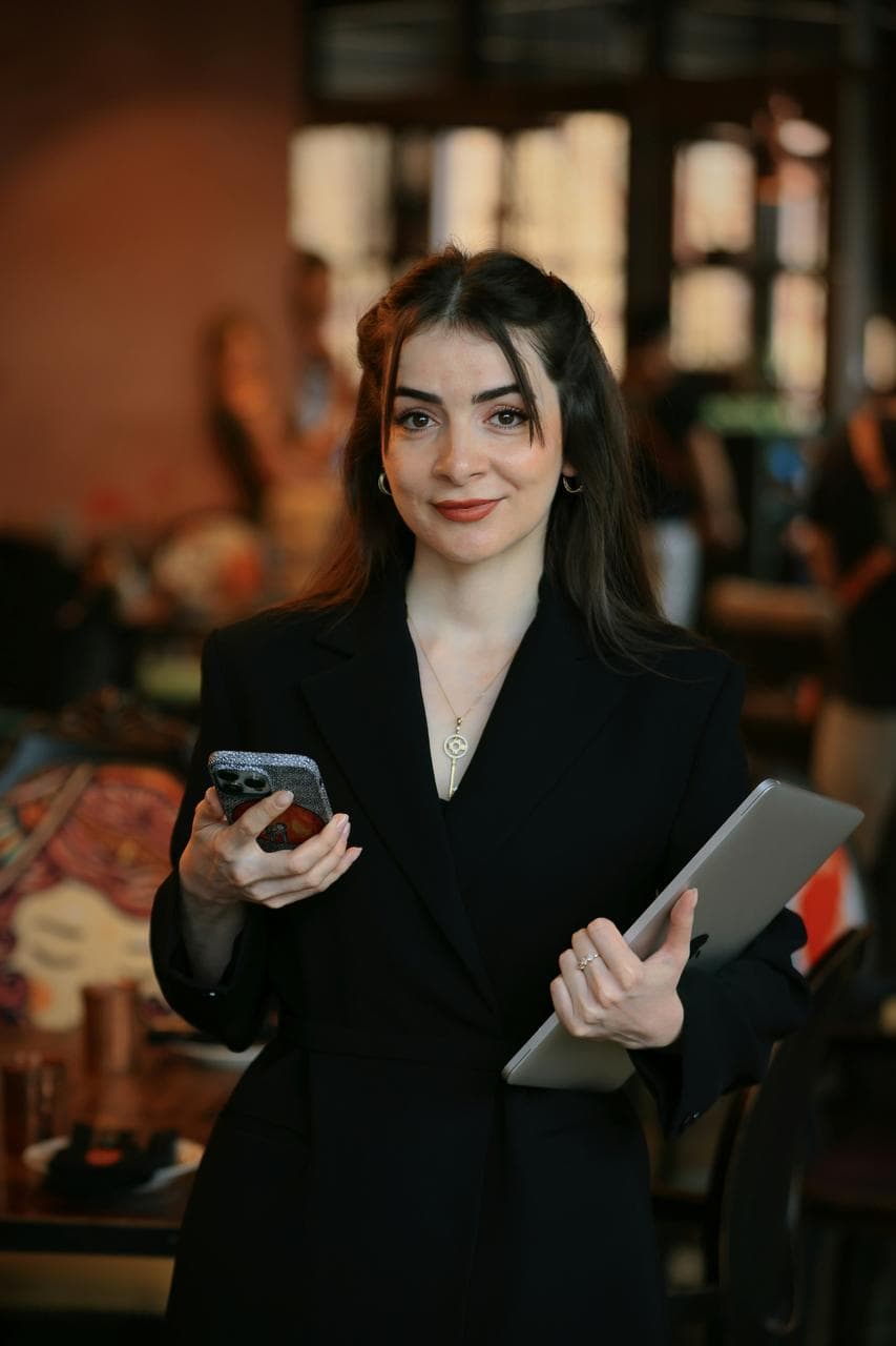 Confident event manager holding a phone and tablet—representing careers in event planning, coordination, and hospitality management.