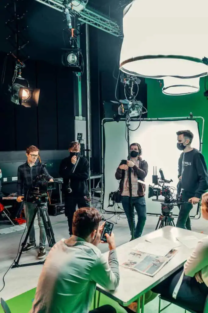 Film and TV production crew on set with cameras, lighting, and green screen—representing media, broadcast, and creative production careers.