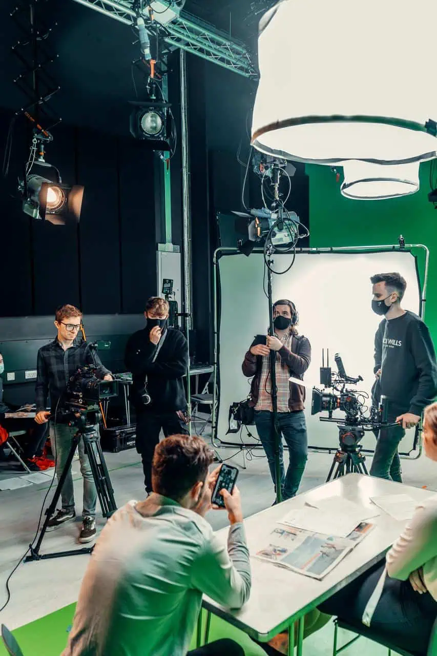 Film and TV production crew on set with cameras, lighting, and green screen—representing media, broadcast, and creative production careers.