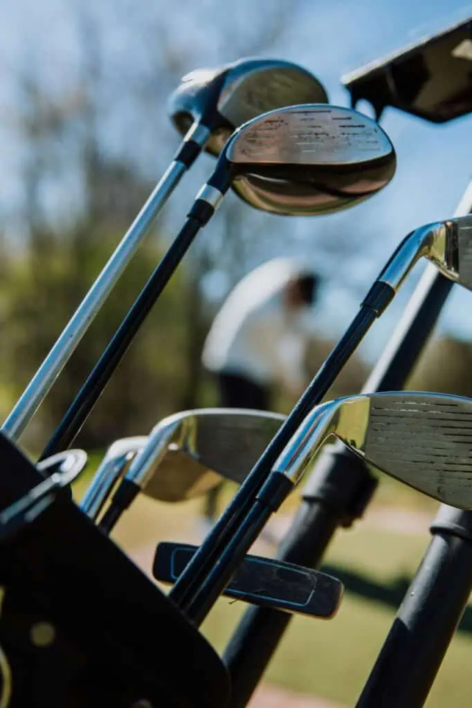 Close-up of golf clubs in a bag at a course, symbolizing the expertise of a golf club fitting and repair specialist in customizing equipment for player performance.