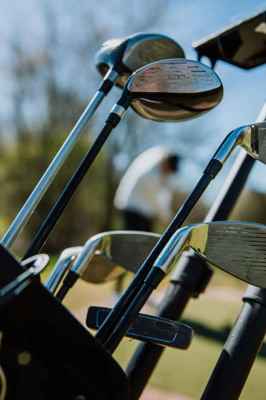 Close-up of golf clubs in a bag at a course, symbolizing the expertise of a golf club fitting and repair specialist in customizing equipment for player performance.