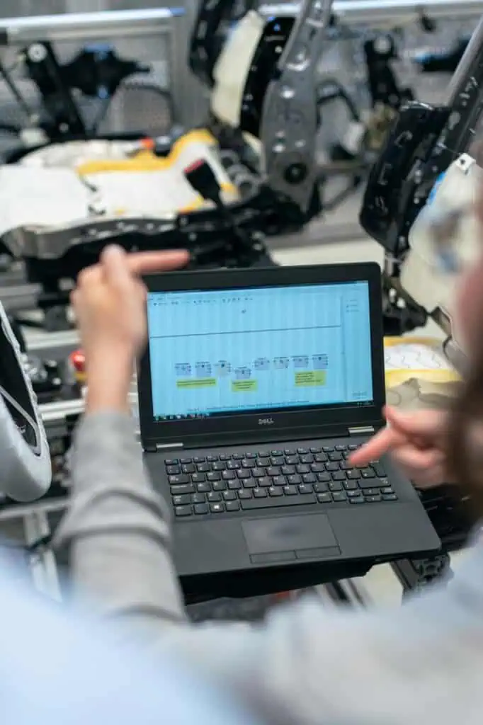 Engineer analyzing automation flowchart on laptop for smart hotel systems and connected technology careers.