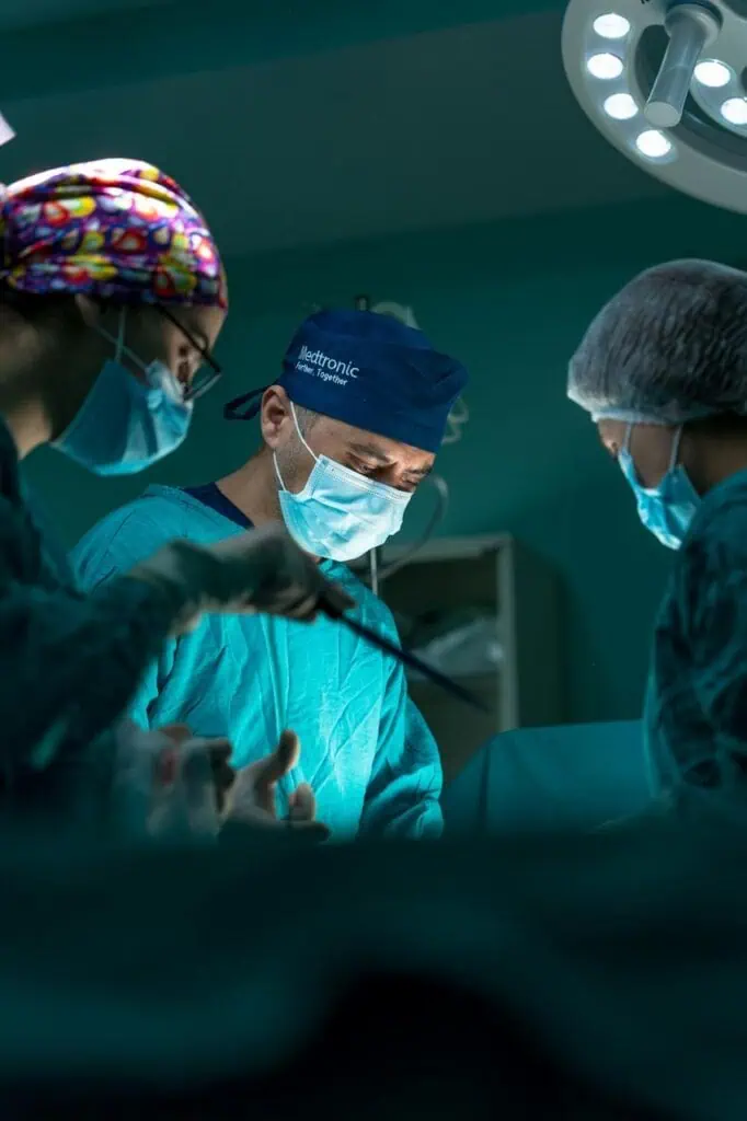 Orthopedic surgeons performing surgery under bright operating room lights.