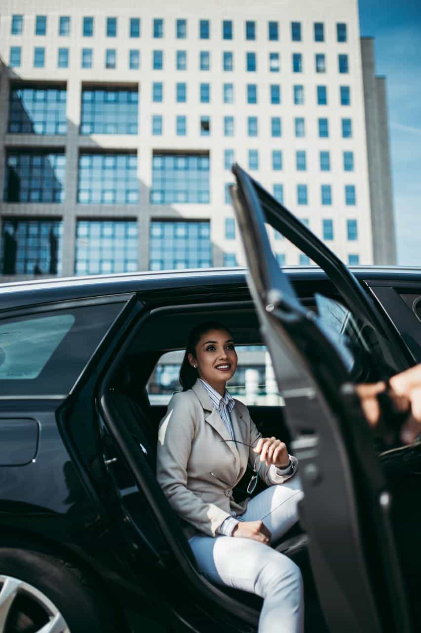 Guest stepping out of a car while a valet opens the door—representing valet parking attendant roles in hospitality and luxury services.
