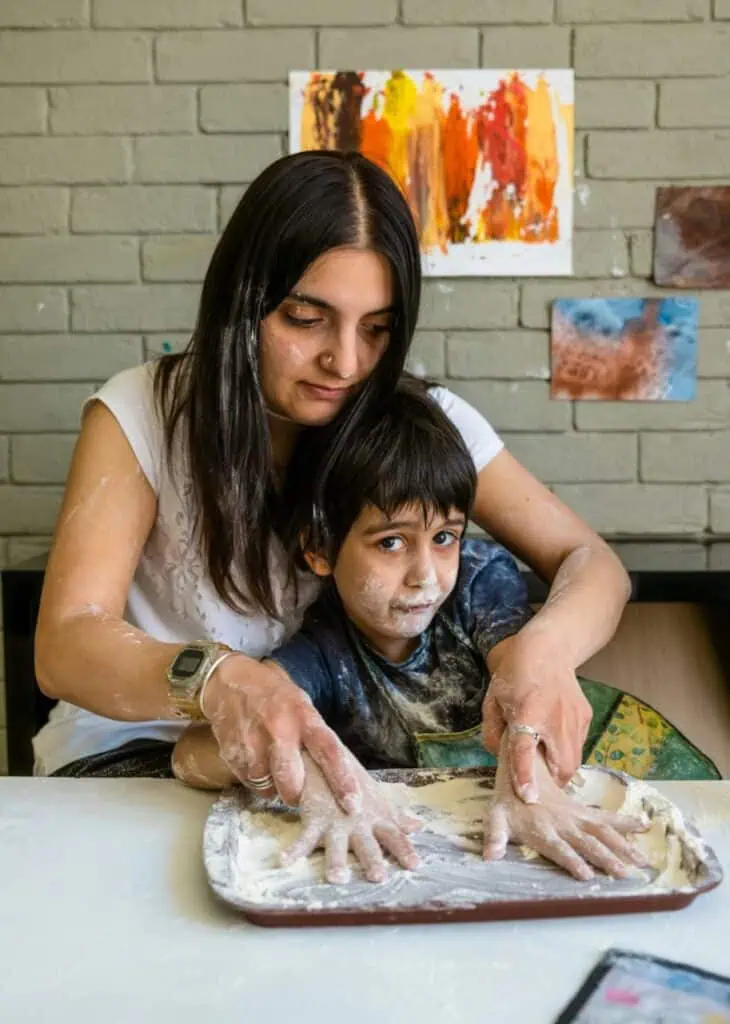 Autism support specialist using clay therapy with special needs child student