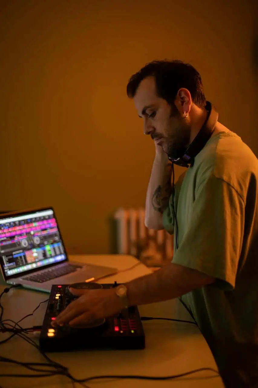 AV technician operating soundboard and laptop for live audio setup