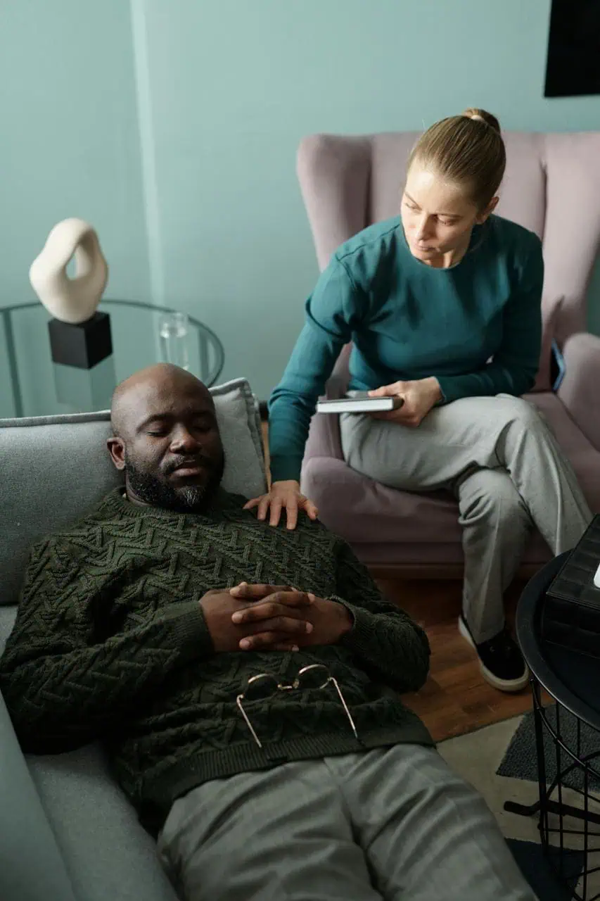 Female grief trauma therapist conducting counseling session with client in office