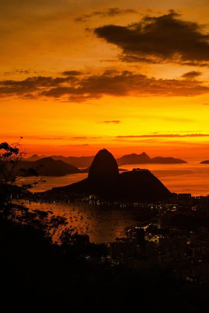 sunset view of Sugarloaf Mountain in Rio de Janeiro with city lights and silhouette skyline
