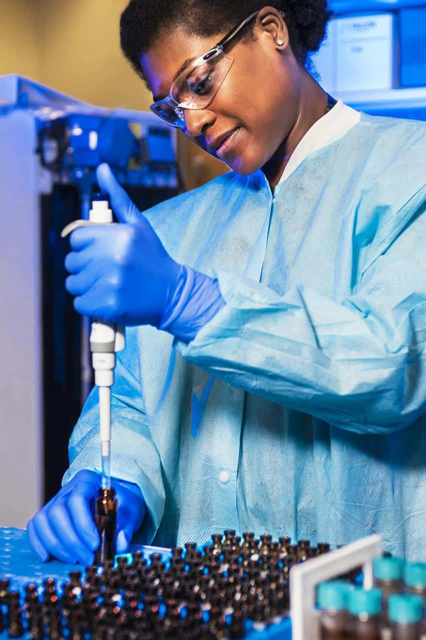 Medical lab technician using pipette for sample testing in laboratory