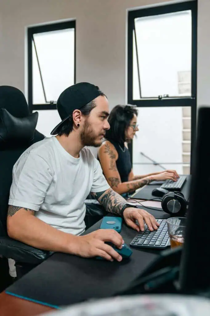 Network administrators managing systems at workstations in modern tech office
