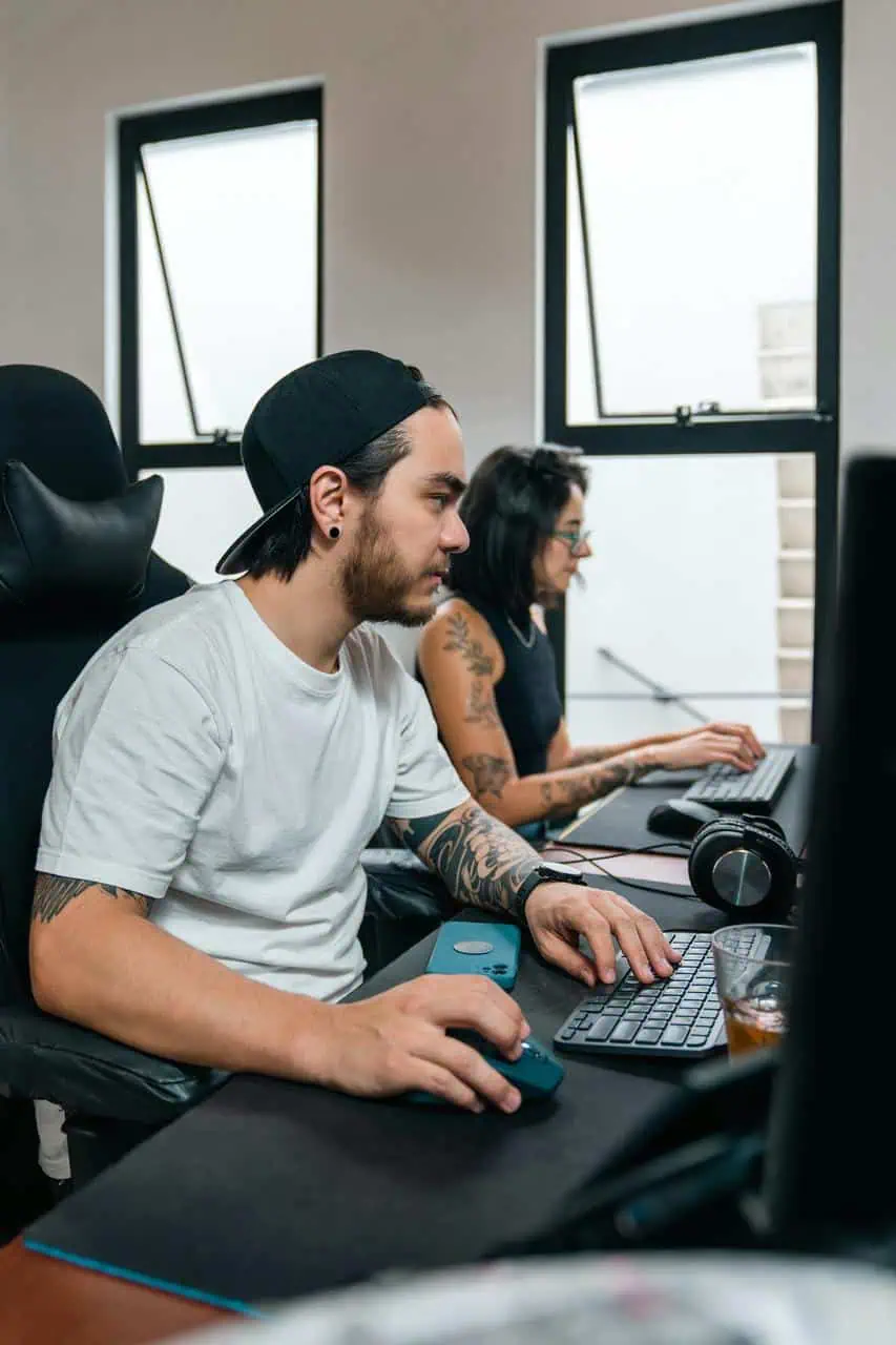 Network administrators managing systems at workstations in modern tech office