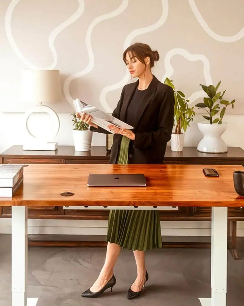 Office furniture sales representative reading catalog in modern workspace