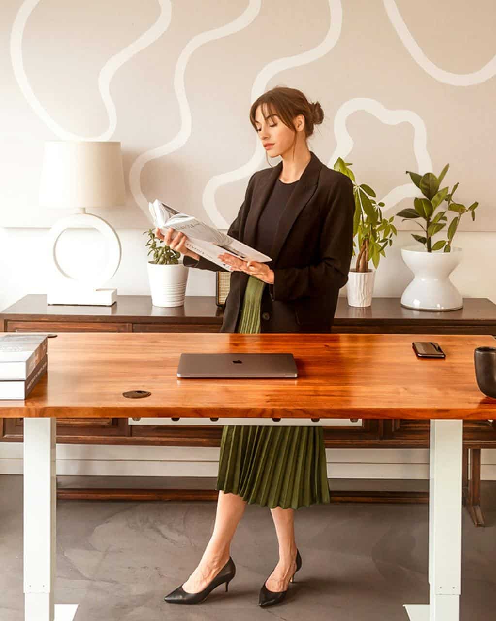 Office furniture sales representative reading catalog in modern workspace