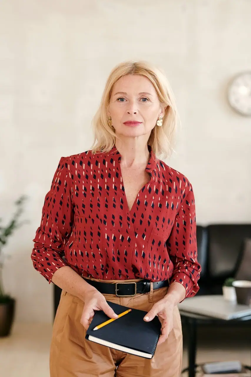 Professional office manager holding notebook and pencil in a modern workspace
