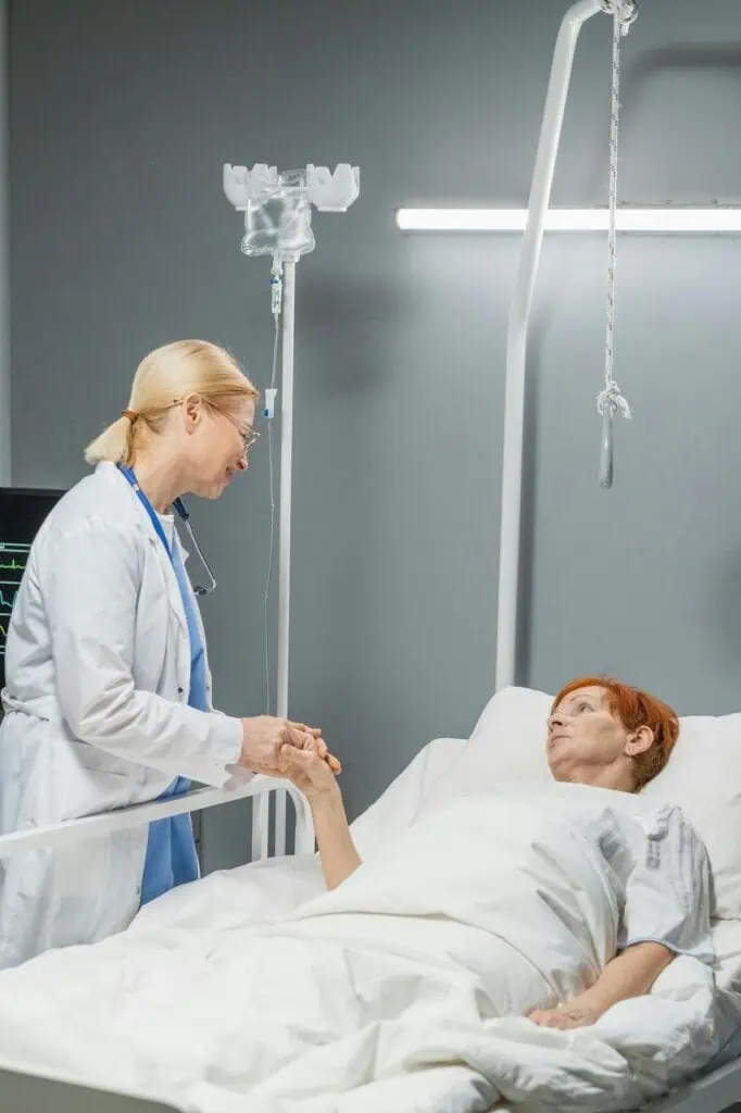 Palliative care nurse providing comfort support to patient in hospital bed
